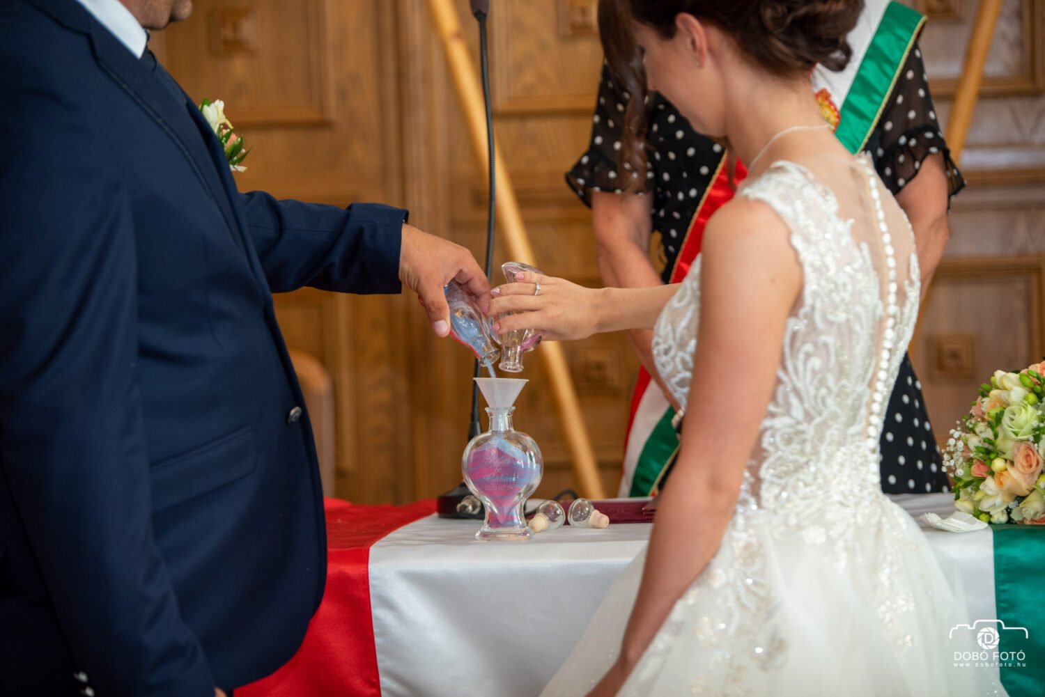 Esküvői homokceremónia Hajdúböszörményben, ahol a menyasszony és a vőlegény egyesítik a színes homokot. Polgári szertartás különleges pillanatai.