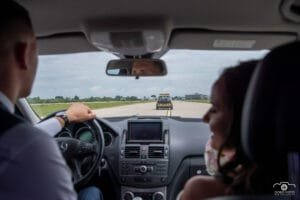 Esküvői kreatív fotózás - Dobó Fotó. Menyasszony és vőlegény autójából nézve a FLYCO jármű vezetése a repülőtér kifutópályáján. Egyedi esküvői élmény különleges helyszínen, belső nézőpontból.