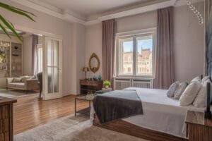 Budapesti belvárosi ingatlan tágas hálószobája, elegáns berendezéssel, nagy ablakokkal, és kilátással az Országházra.