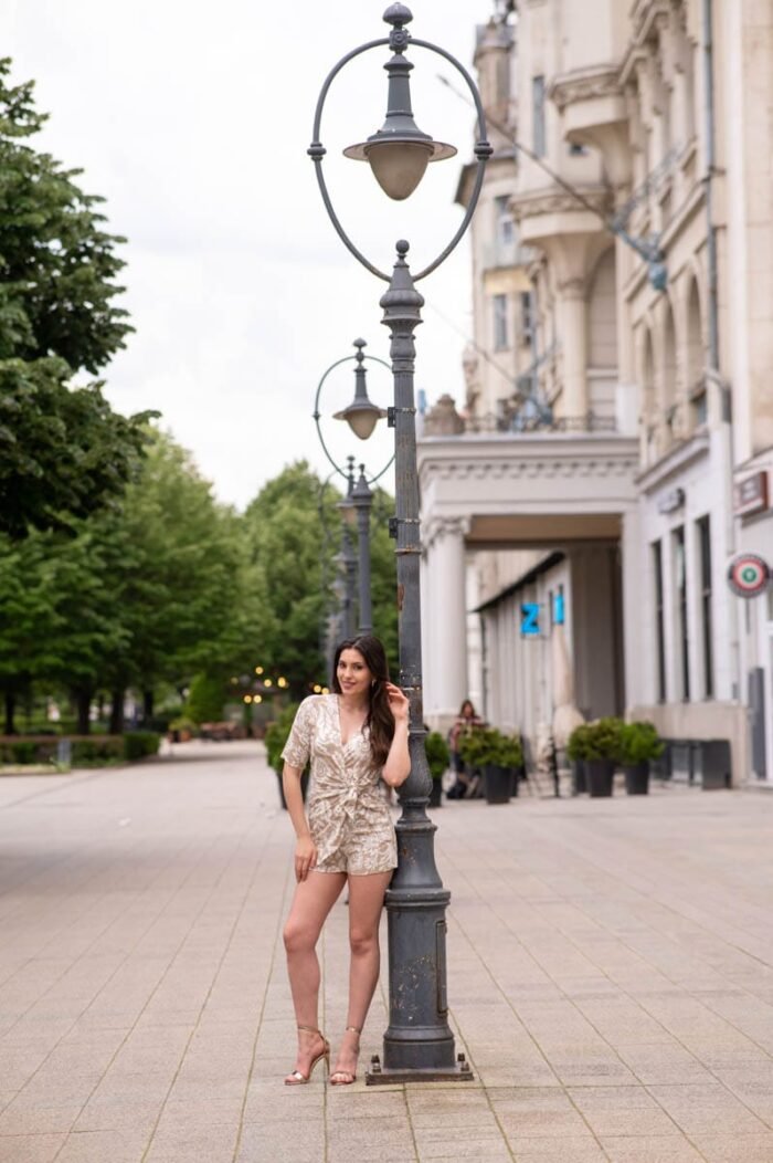 Horváth Krisztina modell mintás ruhában, utcai lámpaoszlop mellett pózol Debrecen belvárosában, az Aranybika Szálloda előtt készült portréfotó.