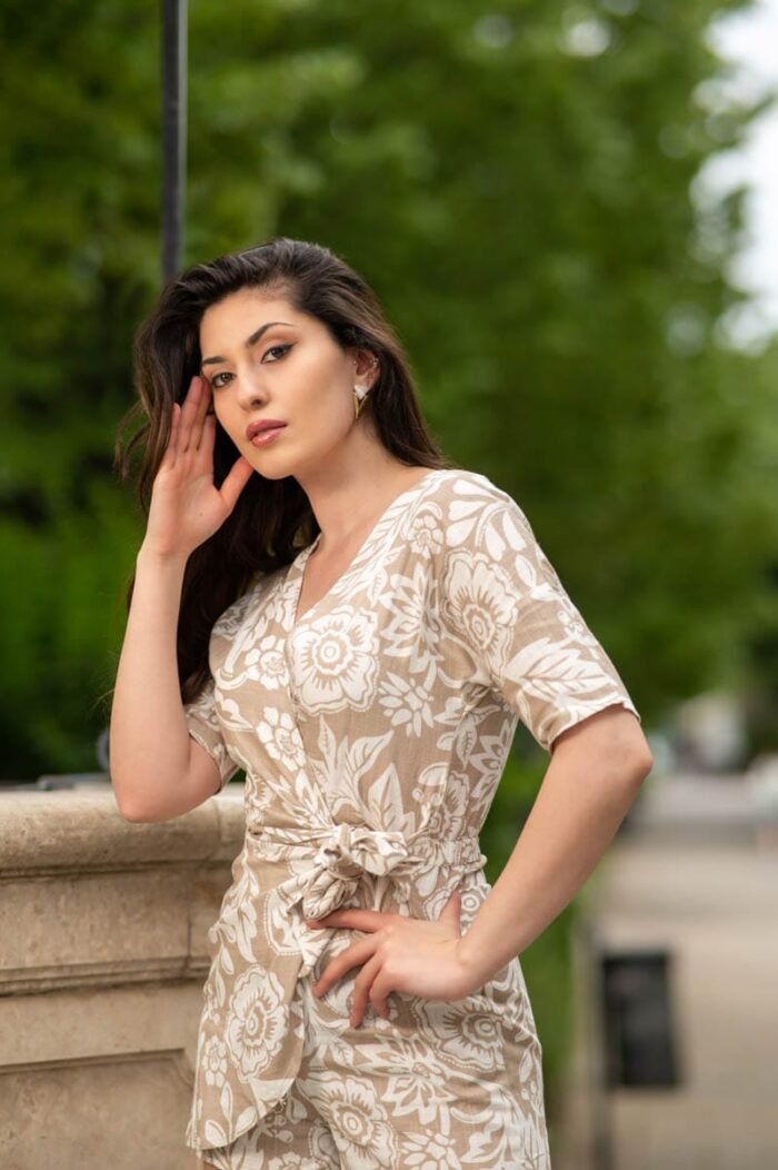 Fiatal nő mintás ruhában, természetes szépséggel pózol egy városi háttér előtt, Debrecenben készült portréfotó.