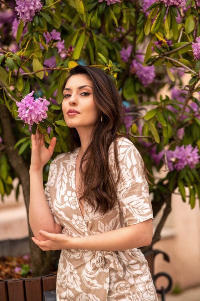 Debreceni fotós által készített portré egy fiatal nőről, virágzó rododendron bokor mellett, természetes fényekkel és romantikus hangulattal.