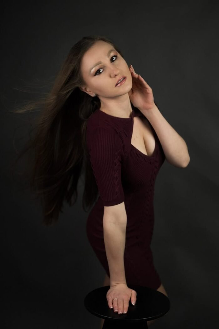Portréfotó debreceni stúdióban, ahol egy hosszú, barna hajú nő bordó ruhában ül egy széken.