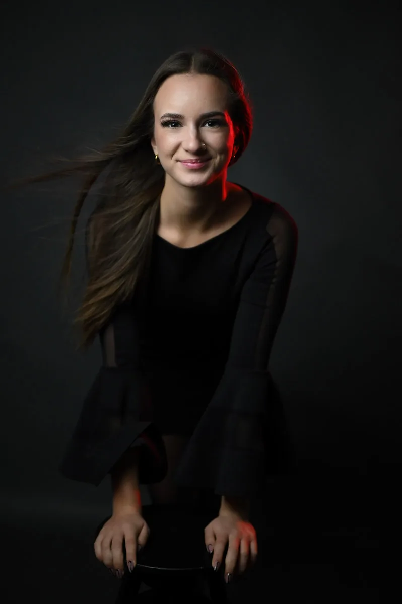 Drámai portré fekete ruhában piros fényben.