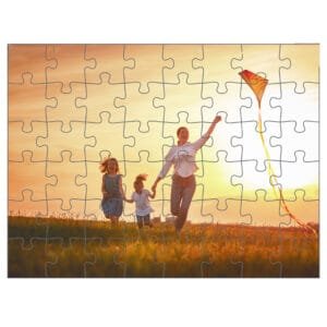 Egy puzzle kép, ami naplemente előtt futó családot ábrázol: egy édesanya két gyermekével szalad egy mezőn, miközben egy piros-narancs sárkányt röptetnek. A kép puzzle darabokra van osztva.