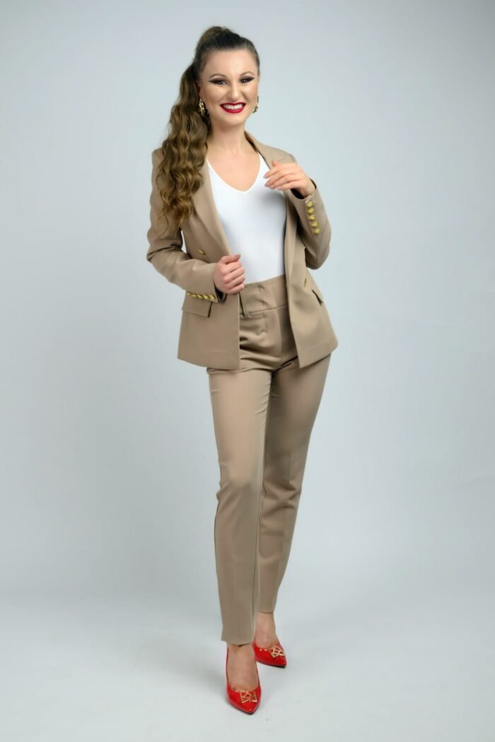 Üzleti portré fotózás során készült kép egy elegáns, bézs kosztümöt viselő hölgy mosolygós pillanatáról Debrecenben.
