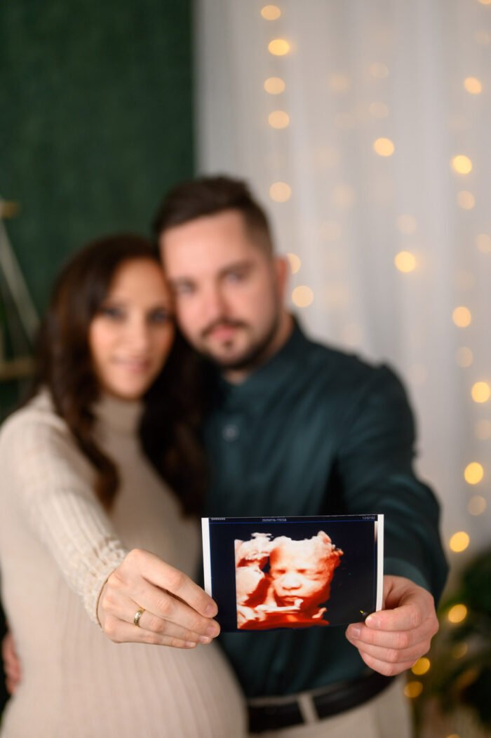 : Kismama és párja meghitt babaváró fotózása Debrecenben, ahol az ultrahangos kép is szerepet kap. Stílusos várandós fényképezés stúdiókörnyezetben, amely örök emlék marad a szülők számára.