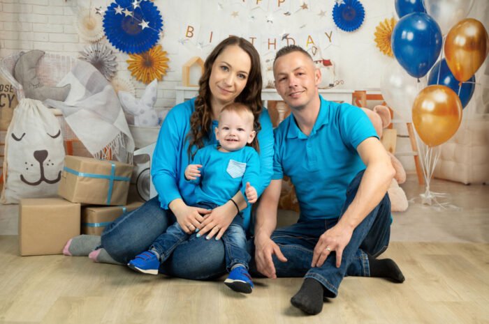 Születésnapi családi fotózás Debrecenben, ahol a család vidám és meghitt pillanatokat örökít meg profi stúdióban. Ünnepi dekoráció, kék-arany lufik és ajándékdobozok teszik még különlegesebbé a fotózást.
