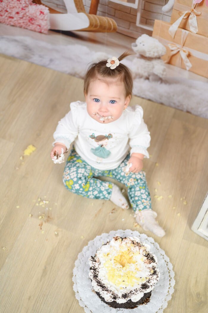Fotós Debrecen – Egyéves kislány tortamaszatolós születésnapi fotózása. Babafotózás vidám és természetes pillanatokkal, profi stúdiókörnyezetben, ünnepi dekorációval.
